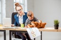 Multitasking businesswoman with her son working at the office Royalty Free Stock Photo