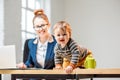 Multitasking businesswoman with her son working at the office Royalty Free Stock Photo