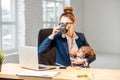 Multitasking businesswoman with her son working at the office Royalty Free Stock Photo