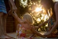 Young mum with blonde daughter girls smiling doing ring around the rosie . Warm sunset light. Family summer travel Royalty Free Stock Photo