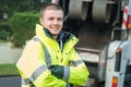 Young municipal garbage collector near garbage truck Royalty Free Stock Photo