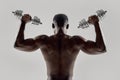 Young muscular african american man lifting weights, standing isolated over grey background. Sports, workout Royalty Free Stock Photo