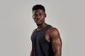 Young muscular african american man looking at camera, while posing isolated over grey background. Sports, workout Royalty Free Stock Photo