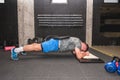 Young muscular attractive and active man workout plank exercise in the gym for strength and conditioning with barbell weight plate Royalty Free Stock Photo