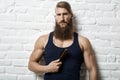 Young muscular bearded white man caring beard