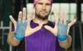 Young muscular hipster athlete shows palm protection grips on hi