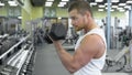 Young muscular man doing exercise with dumbbells in the gym. portrait of male bodybuilder at the gym exercising Royalty Free Stock Photo