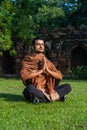 Young muscular man doing yoga on grass wearing a cap Royalty Free Stock Photo