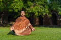 Young muscular man doing yoga on grass wearing a cap Royalty Free Stock Photo