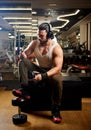 Young muscular man exercising in gym and listening music Royalty Free Stock Photo