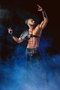 Young and muscular man performing a theatrical pose on stage. Royalty Free Stock Photo
