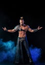 Young and muscular man performing a theatrical pose on stage. Royalty Free Stock Photo