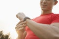 Young muscular man with red shirt looking down and checking his watch, outdoors in Beijing Royalty Free Stock Photo