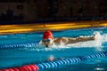 Young muscular man showing competitive spirit, swimmer in cap and goggles training, swimming in pool, preparing for Royalty Free Stock Photo