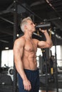 Young muscular man showing his perfect body. Man drinking from a cocktail shaker with the protein. Toned image Royalty Free Stock Photo