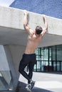 Young muscular shirtless caucasian man doing pull-ups outdoor in sunny summer`s day Royalty Free Stock Photo