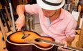 Young musician changing strings on a classical guitar in a guitar shop Royalty Free Stock Photo