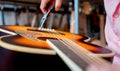 Young musician changing strings on a classical guitar in a guitar shop Royalty Free Stock Photo