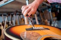 Young musician changing strings on a classical guitar in a guitar shop Royalty Free Stock Photo