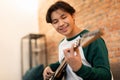 Cheerful Asian Teen Boy Playing Electric Guitar At Home Royalty Free Stock Photo