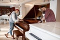 Young musician couple choosing new instrument for family band at shop