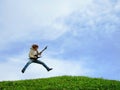 Young musician jumps with guitar Royalty Free Stock Photo