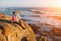 Young musician play the trumpet on rocky sea coast during surf. Royalty Free Stock Photo