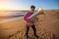 Young musician play the trumpet on rocky sea coast during surf. Royalty Free Stock Photo