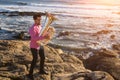 Young musician play the Tuba on rocky sea coast during surf. Royalty Free Stock Photo