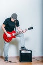 Young musician with red guitar isolated on white. Rockstar man playing electric guitar. Guy with a guitar combo Royalty Free Stock Photo