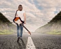 Young musician woman walking on a road Royalty Free Stock Photo