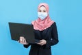 Young muslim asian business woman with traditional dress in black suit wearing medical face mask under the outbreak of the virus, Royalty Free Stock Photo