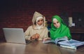 Young muslim asian female designer using graphics tablet while working with computer at studio or office. Royalty Free Stock Photo