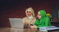 Young muslim asian female designer using graphics tablet while working with computer at studio or office. Royalty Free Stock Photo