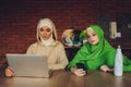 Young muslim asian female designer using graphics tablet while working with computer at studio or office. Royalty Free Stock Photo