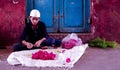 Bangalore, Karnataka / India - July 01 2019: A young muslim boy wearing white skull cap selling flowers at Russel market sitting o