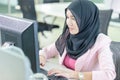 Young muslim businesswoman in an office, young Arabic woman in headscarf using a laptop