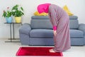 Young Muslim caucasian Female Praying Ruku at home.