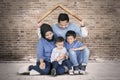 Young Muslim family plays under a roof symbol Royalty Free Stock Photo