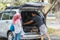 Young muslim family , transport, leisure, road trip and people concept - happy man, woman and little girl getting ready for Royalty Free Stock Photo