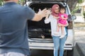 Young muslim family , transport, leisure, road trip and people concept - happy woman and little girl waving at father to say Royalty Free Stock Photo