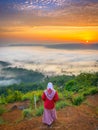 Young muslim girl watching sunrise in the land above the clouds