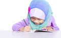 Young muslim girl writing a book on the desk