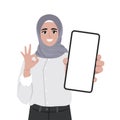 Young muslim happy woman shows smartphone with ok sign