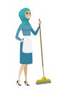 Young muslim housemaid sweeping floor with a broom