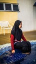 Young Muslim Malay girl with hijab sitting at the stairs at the swimming pool Royalty Free Stock Photo