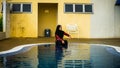 Young Muslim Malay girl with hijab sitting at the stairs at the swimming pool Royalty Free Stock Photo