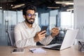 Young muslim man businessman sitting in office at desk and using mobile phone and credit card Royalty Free Stock Photo