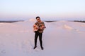 Handsome male Arab playing guitar standing in middle of bottomle