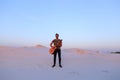 Handsome male Arab playing guitar standing in middle of bottomle